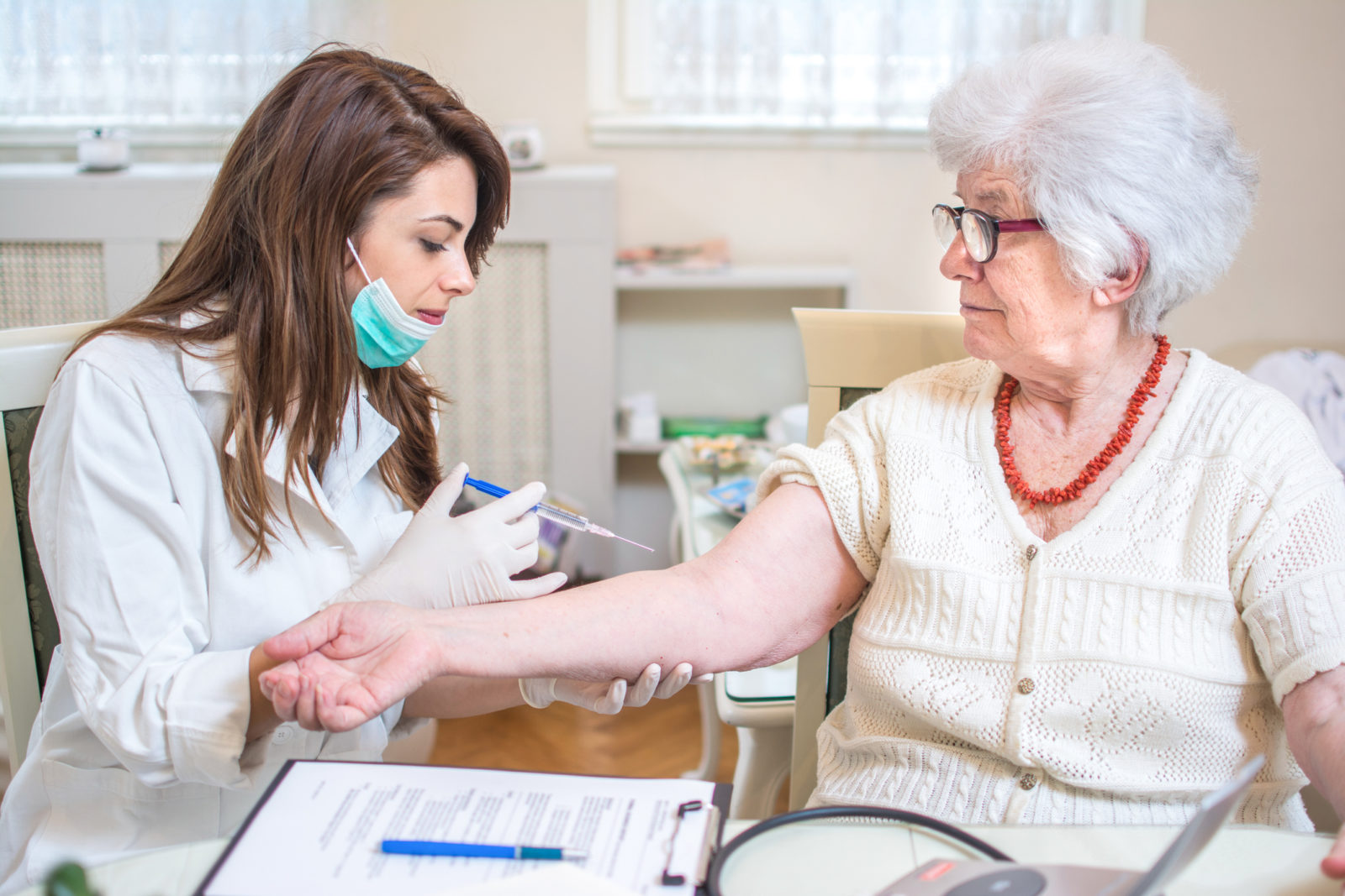 Nurse injecting vaccine to senior's woman arm.