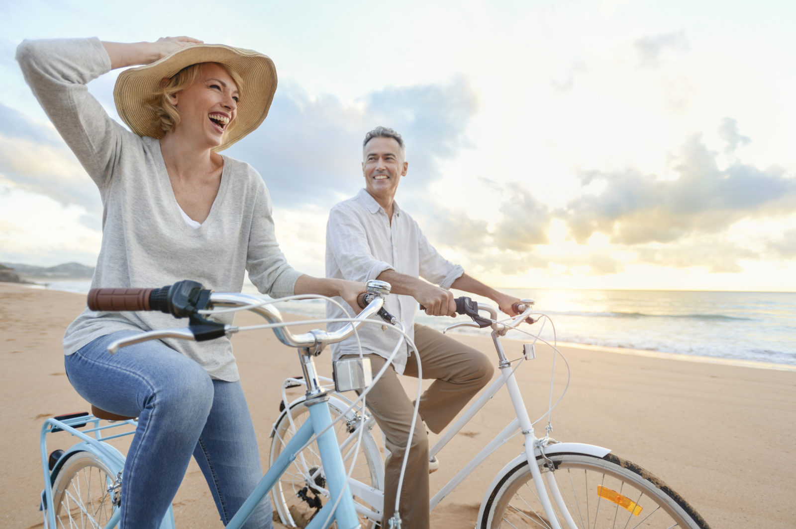 Older couple riding bikes on the beach