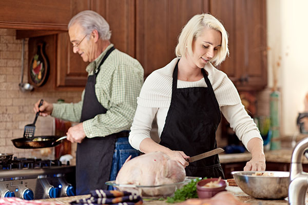 woman preparing Thanksgiving dinner with elderly father