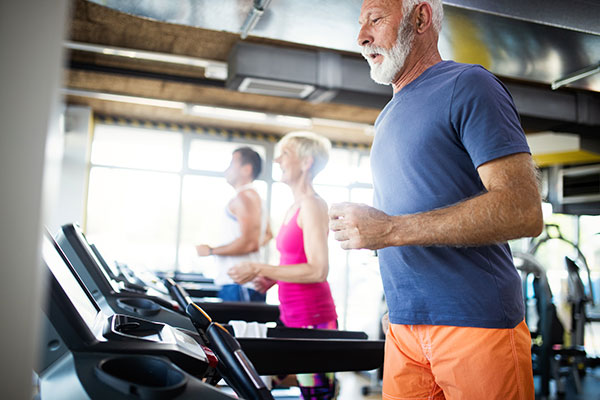 older man on treadmill in gym