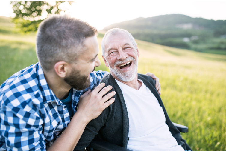 elder man outdoors with son laughing