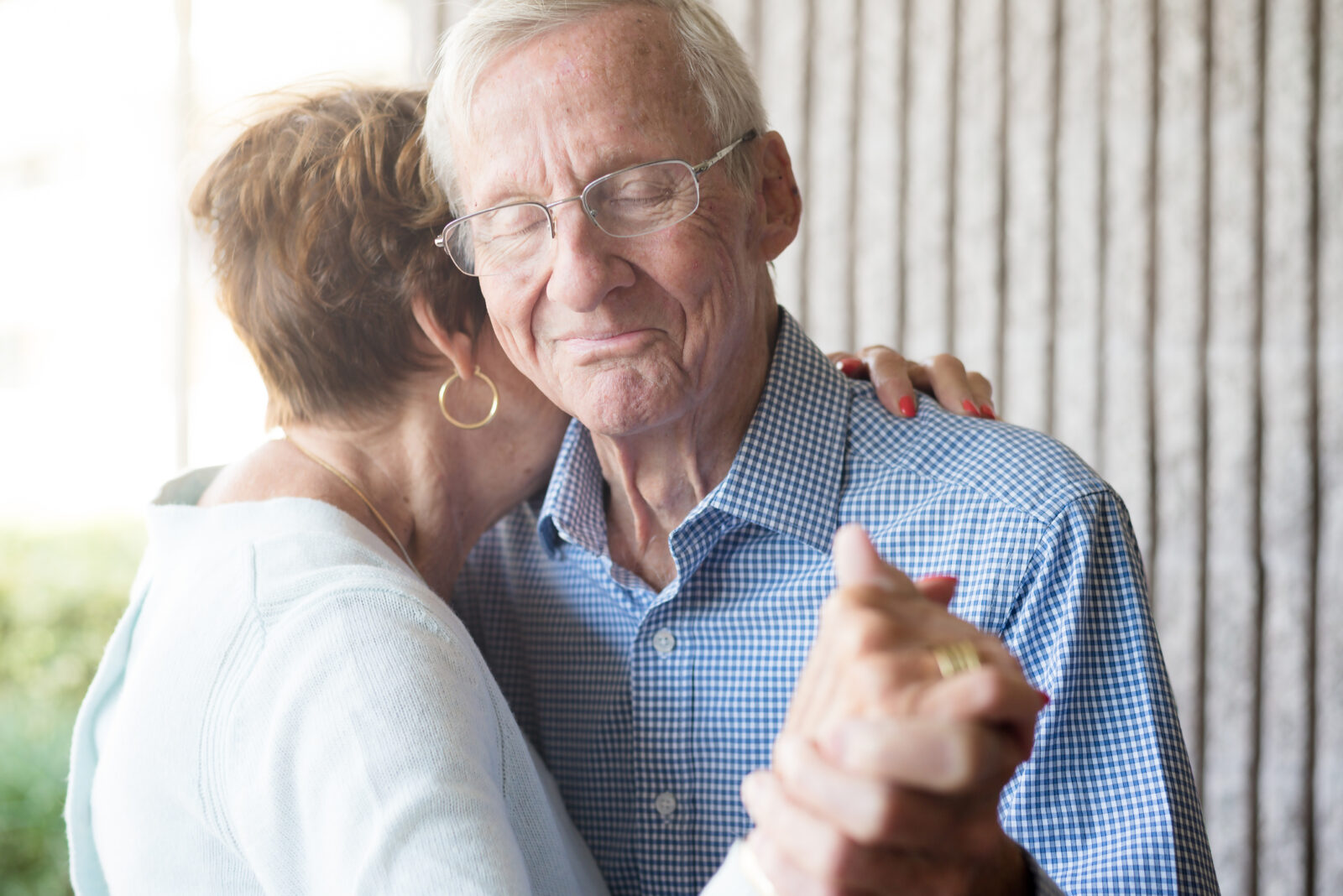 Portrait of senior couple embracing and dancing holding hands