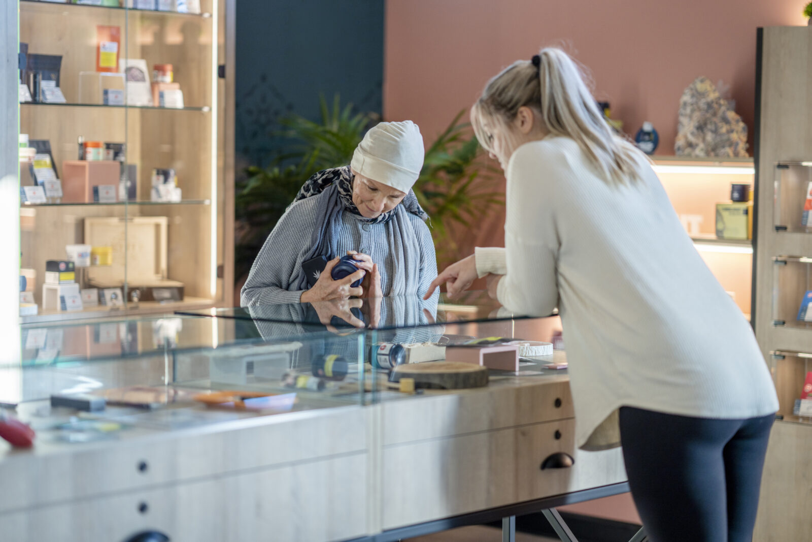 A senior woman is seen behind the counter of a legal cannabis retailer as she shops for product.