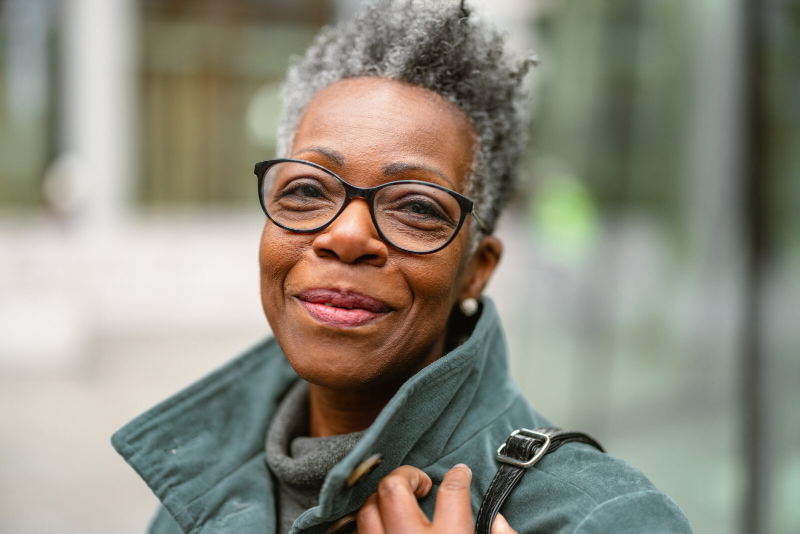 A portrait of a senior adult black female outdoors looking at the camera.